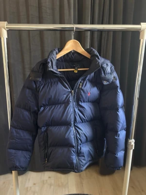 Ralph Lauren Vinter Jacka - Den har få små skrap hål som inte syns om man inte kollar noga och det påverkar inte jackan alls.  Märke: Ralph Lauren  Storlek: XL i barn Så XS i herr Färg: Blå Skick:6;5 Hör av dig vid frågor!🙌