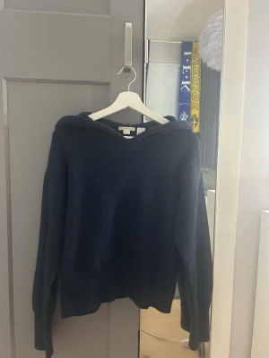 Mörkblå stickad hoodie - Säljer en mörkblå stickad hoodie som passar perfekt snart till hösten, lite nopprig men inget man tänker på!!💕