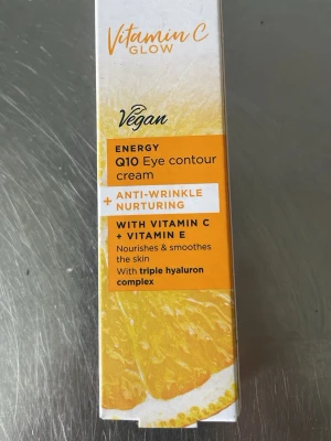 Vitamin C Glow Q10 ögonkräm vegan - Vitamin C Glow Q10 Eye contour cream är en vegansk ögonkräm med anti-rynkeffekt. Innehåller vitamin C, vitamin E och triple hyaluron complex som återfuktar och slätar ut huden runt ögonen. Kommer i en vit och orange förpackning.