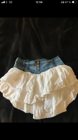 Vit volangkjol med jeansmidja - Supersöt kort kjol med jeansmidja och tre dekorativa knappar framtill. Lite somrig Stockholmsstil! (Lägger upp artiklar från min vinted därav det svarta runt som jag inte orkat croppa bort) 
