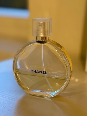 Chanel Chance Eau Fraîche parfym - Chanel Chance Eau Fraîche parfym i en rund, transparent glasflaska med guldfärgad kant och spraymunstycke i frostat plast. Doften är fräsch och elegant, perfekt för dig som gillar exklusiva och klassiska parfymer. Flaskan har tydlig Chanel-logga och stilren design. Använt mer än hälften💞