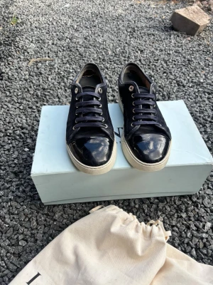 Lanvin dbb1 - Snygga mörkblå  lanvins Uk 6med glansiga  på tån och klassisk vit sula. Skorna har navy blue snören och  stilren look. Perfekta för dig som gillar en clean och modern stil.