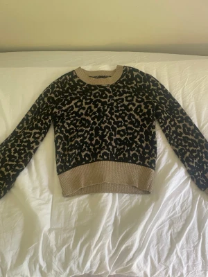 Leopardmönstrad stickad tröja - Snygg glittrig stickad tröja med leopardmönster. Tröjan har rund halsringning, ribbade muddar och nederkant. Storlek xs. Pris kan diskuteras😁