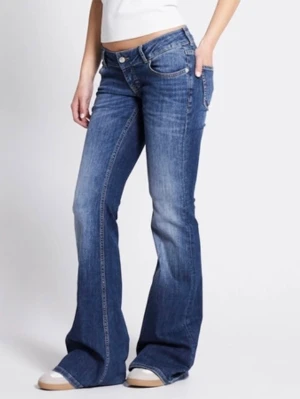 Blå bootcut jeans med låg midja - Snygga blå bootcut jeans med låg midja och klassiska fem fickor. Jeansen har en lätt tvättad look och vida ben som ger en retrovibe. Perfekta att styla med sneakers eller boots för en avslappnad stil. De är väldigt bra skick och jag säljer då för att jag inte använder dem. 