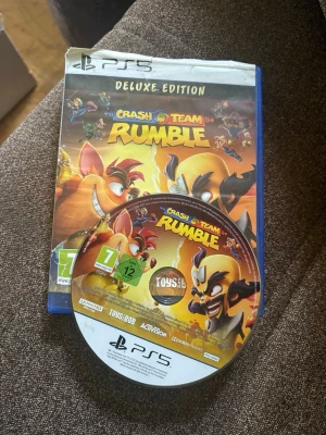 Crash Team Rumble - Crash Team Rumble Deluxe Edition till PS5. Fodral och skiva med färgstark grafik där Crash Bandicoot och andra karaktärer syns i actionfylld miljö. Spelet är från Activision och Toys for Bob och har PEGI 7-märkning. Perfekt för dig som gillar partyspel och plattform.
