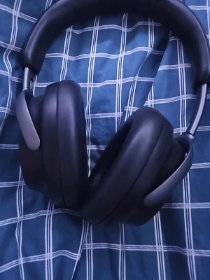 Svarta over-ear hörlurar - Snygga svarta over-ear hörlurar med mjuka, ovala öronkuddar och justerbar bygel. Designen är stilren och modern med mattsvarta detaljer och metallinslag. Perfekta för att lyssna på musik eller poddar med grym komfort under längre sessioner.