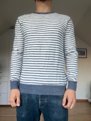 Blå och vit randig tröja  - Randig tröja från märket Reserved. Tröjan är tillverkad i 100% bomull. Strl S. Inga defekter. Modellen är 178 cm och väger 77 kg. Hör gärna av dig vid frågor!