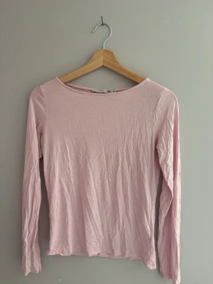 Ljusrosa långärmad topp - En enkel och stilren ljusrosa långärmad topp med rund halsringning. Toppen är i ett mjukt och tunt material som känns skönt mot huden. Perfekt att matcha med jeans eller kjol för en avslappnad look. Bra skick. Skriv privat för mer information. 