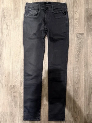 Replay Anbass Hyperflex Jeans Mörkgrå W32/L34 - Slim Fit - Replay Anbass Hyperflex mörkgrå jeans i stretchig Hyperflex denim med slim fit passform som sitter snyggt och bekvämt och funkar till allt, storlek W32/L34, midja 39 cm, ytterbenslängd 111,5 cm, benöppning 15 cm, modellen är 185cm & väger 65kg, i fint skick.