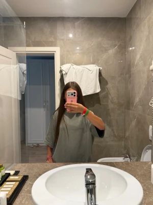 Oversized grön t-shirt - Säljer en oversized grön t-shirt med korta ärmar och rund hals. T-shirten har en enkel och clean design utan tryck eller mönster, perfekt för en avslappnad stil. Materialet känns mjukt och bekvämt mot huden.