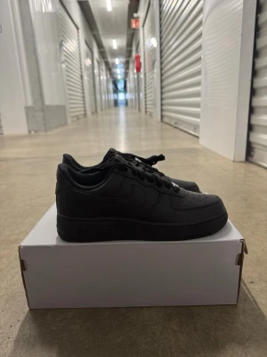 Nike Air Force 1 '07 Svarta Sneakers strl 40 - Helt nya oanvända Nike Air Force 1 '07 Svarta Sneakers strl 40.  Skorna har inte blivit använda eller testade. Original kartong medföljer  Nypris hos Nike 1400 kr.