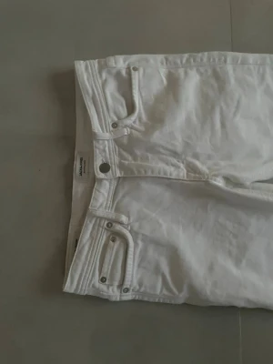 Vita slim fit jeans från Jack & Jones - Säljer ett par vita slim fit jeans från Jack & Jones, modell Glenn. Jeansen har klassisk femficksdesign, silverfärgade nitar och knappstängning. Perfekta för dig som gillar en smalare passform och stilren look.