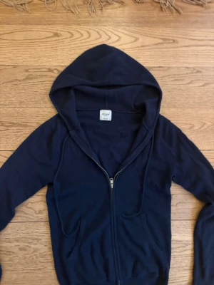 Mörkblå cashmere hoodie John Henric - Mysig mörkblå hoodie från John Henric i 100% cashmere. Tröjan har dragkedja framtill, två fickor och en stor huva. Perfekt för dig som vill ha något både stilrent och bekvämt. Passar till det mesta och är supermjuk mot huden. Nypris 2999kr