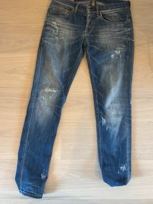 Blå Dondup jeans - Ett par rikigt snygga Dondup  jeans med slitningar och distressed detaljer på både fram- och baksida. Jeansen är i fint skick och ser väldigt frächa ut på. För fler frågor är det bara att skriva 🙌