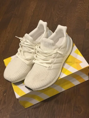 Vita Adidas Ultra Boost sneakers - Säljer ett par fräscha vita Adidas Ultra Boost 4.0. Använda ett par gånger. Skick 9/10. Priset är ej hugget i sten! 