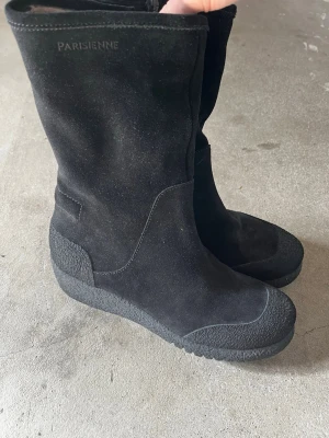 Svarta mockastövlar från Parisienne - Snygga svarta stövlar från Parisienne i mocka med grov sula och förstärkt tåparti. Stövlarna har en enkel, stilren design och päls inuti för extra värme under vintern. Perfekta för dig som vill ha både stil och funktion under kalla dagar. Helt nya med prislapp😊