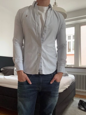 Ljusblå randig Ralph Lauren skjorta - Säljer en ljusblå och vit randig skjorta. Storleken är i M men passar S och det står 165cm på lappen!! Perfekt för en clean och stilren look.      Kom pm för frågor!!