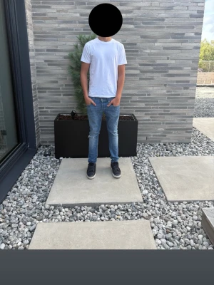 Don Dup Gorge  - Dondup George Skinny Fit jeans i blå denim, storlek W33. Snygg smal modell med klassisk blå tvätt, naturliga slitningar och ett hål vid ena knät. Personen på bilderna är 189 cm lång och väger ca 76 kg. Jeansen är i fint begagnat skick med normala spår av användning. Tillverkade i Italien. Nypris ca 2 000–2 500 kr.