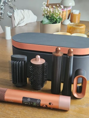 Dyson airwrap i.d - Säljer en multistyler för hår i koppar och svart med flera utbytbara tillbehör som borstar och locktänger. Allt kommer i en snygg oval förvaringsväska. Perfekt för dig som vill fixa olika frisyrer hemma. Använd några enstaka gånger. Köpt i april. Kvitto finns.