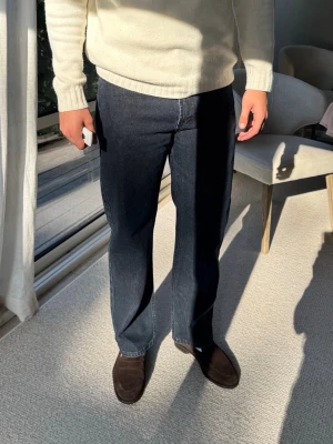 Mörkblå raka jeans med kontrastsömmar - Säljer ett par mörkblå jeans med raka ben och tydliga kontrastsömmar. Jeansen har klassisk femficksdesign och är tillverkade i kraftigt denimtyg. Passformen är avslappnad och stilen är tidlös, perfekt för dig som gillar en clean look. Waist 34, lenght 32.