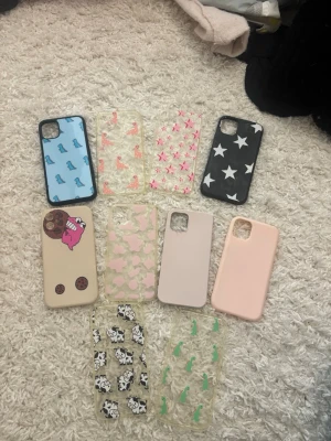 iPhone 11/12 skal - Säljer ett gäng mobilskal i olika färger och mönster, bland annat stjärnor, dinosaurier, kossor, rosa stjärnor och abstrakta figurer. Skalen är gjorda i plast och silikon och finns i både transparenta och täckande varianter. Perfekt för dig som vill byta stil på mobilen ofta!