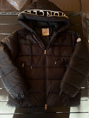 Svart Moncler jacka - Säljer en snygg och varm jacka från Moncler! Jackan är i mycket bra skick och har inga defekter förutom att innerfickan är lite seg. Annars nyskick! Moncler text på luvan men man kan även dölja de (se bild) Nfc-scan och qr-kod funkar som de ska! Perfekt till vintern. Om ni har några frågor så hör av er😊