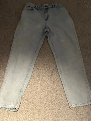 Ljusblå jeans från grunt - Säljer ett par ljusblå jeans från grunt med hög midja och raka ben. Klassisk femficksmodell i mjukt denimtyg. Perfekta för en avslappnad och trendig look. Rätt så smutsiga och helt ok skick men om ni tvättar det blir bättre!  Om ni vill ha bättre skick på jeansen Rekommenderar jag att kolla i min profil. men också ifall du söker en annan färg eller bara ett par andra jeans eftersom jag har flera andra jeans i olika färger!