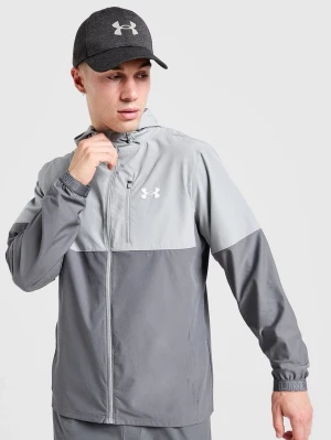 Grå vindjacka från Under Armour - Snygg tvåtonad grå vindjacka från Under Armour med dragkedja framtill och huva. Jackan har en bröstficka med dragkedja, elastiska muddar och logga på bröstet. Perfekt för blåsiga dagar och sportiga outfits.