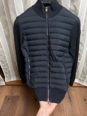 Moncler cardigan - Navy moncler cardigan with black logo. Perfect condition except a small flaw on the sleeve (last picture). Authentic moncler. Bought from vestiaire and it passed the authentication system but I have never used it myself because it’s little too small for me. So the vestiaire tag is still attached. Couldn’t add anymore pictures so ask for more for example the tags and in wear. 