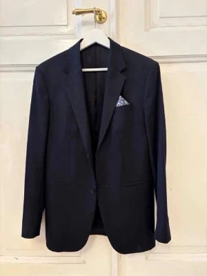 COS KAVAJ - Säljer denna snygga mörkblåa kavajen från COS, perfekt över en tisha exempelvis! Köpt för ca 2500kr, säljer för 749kr👌Toppen skick, storlek 46. Modellen är ca 185cm.