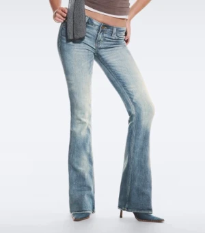 Ljusblå bootcut jeans med slitningar - Säljer ett par ljusblå bootcut jeans med snygga slitningar och tvättade detaljer. Jeansen har klassisk femficksmodell, låg midja och utsvängda ben. 