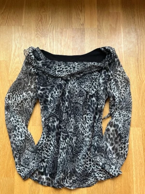 Off shoulder blus  - En off shoulder blus med mönster på och en liten knut på. Storlek S/M står inte märke på 