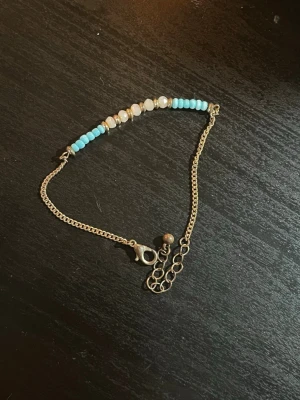 Trw armband med pärlor och hjärtan - Säljer två armband: ett med små turkosa och vita pärlor på tunn kedja i metall, och ett elastiskt armband med vita facetterade pärlor, bruna detaljer och rosa hjärtformade pärlor. Samt ett silvrigt elastiskt armband. Perfekt för dig som gillar söta och färgglada accessoarer. 20kr styck eller 30 för två 45 för alla tre 
