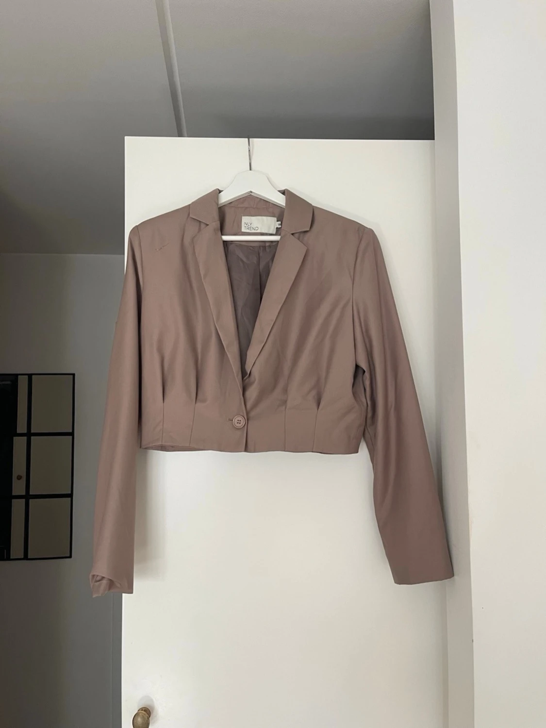 Kort beige kavaj med en knapp