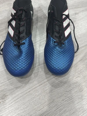 Adidas ACE 17 Primemesh - Snygga fotbollsskor i blått och svart med vita detaljer och svarta skosnören. Skorna har en strukturerad ovandel för bättre bollkontroll och klassisk snörning. Perfekta för dig som vill sticka ut på planen.
