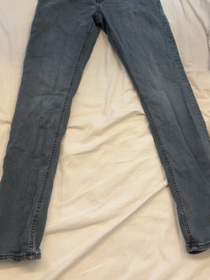 Grå slim fit jeans jack&jones - Snygga blå slim fit jeans med klassisk femficksdesign och smala ben. Jeansen har en enkel look utan slitningar och är perfekta till en avslappnad stil. Tillverkade i mjukt denimtyg som ger en skön känsla hela dagen.