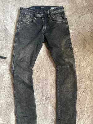 Svarta Replay jeans med smal passform - Säljer ett par svarta Replay jeans med slim passform och klassisk femficksdesign. 