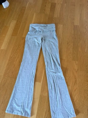 Grå bootcut yoga pants - Snygga grå yoga pants med bootcut-ben och låg midja Tillverkade i ett mjukt och stretchigt material som sitter skönt på kroppen. 