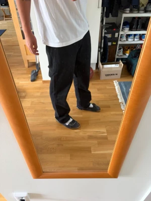 Svarta raka jeans herr - Säljer ett par svarta jeans med rak passform och klassisk femficksdesign. Jeansen har normal midja och är tillverkade i ett kraftigare denimtyg. Perfekta för en avslappnad och stilren look. Storlek: 32/32