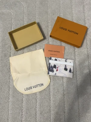 L och V vit korthållare med vintermotiv - Säljer en exklusiv vit korthållare med vinterinspirerat tryck av skidåkare, liftar och granar. Kommer med original ask, dustbag och kort. Perfekt för dig som vill ha något unikt och stilrent i fickan.