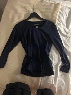 Mörkblå långärmad topp - En stilren mörkblå långärmad topp från MQ med rund halsringning. Toppen har en figurnära passform och är tillverkad i ett mjukt, stretchigt material som känns bekvämt mot huden. Perfekt att matcha med jeans eller kjol för en enkel och snygg look. Den är aldrig använd och köpt för ungefär 400-500 kr ❤️