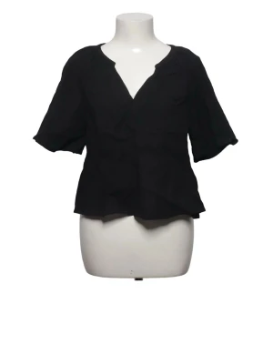 Svart blus med v-ringning - Stilren svart blus med v-ringad hals och avslappnad passform. Blusen har korta ärmar. Perfekt att matcha med jeans eller kjol för en trendig look.