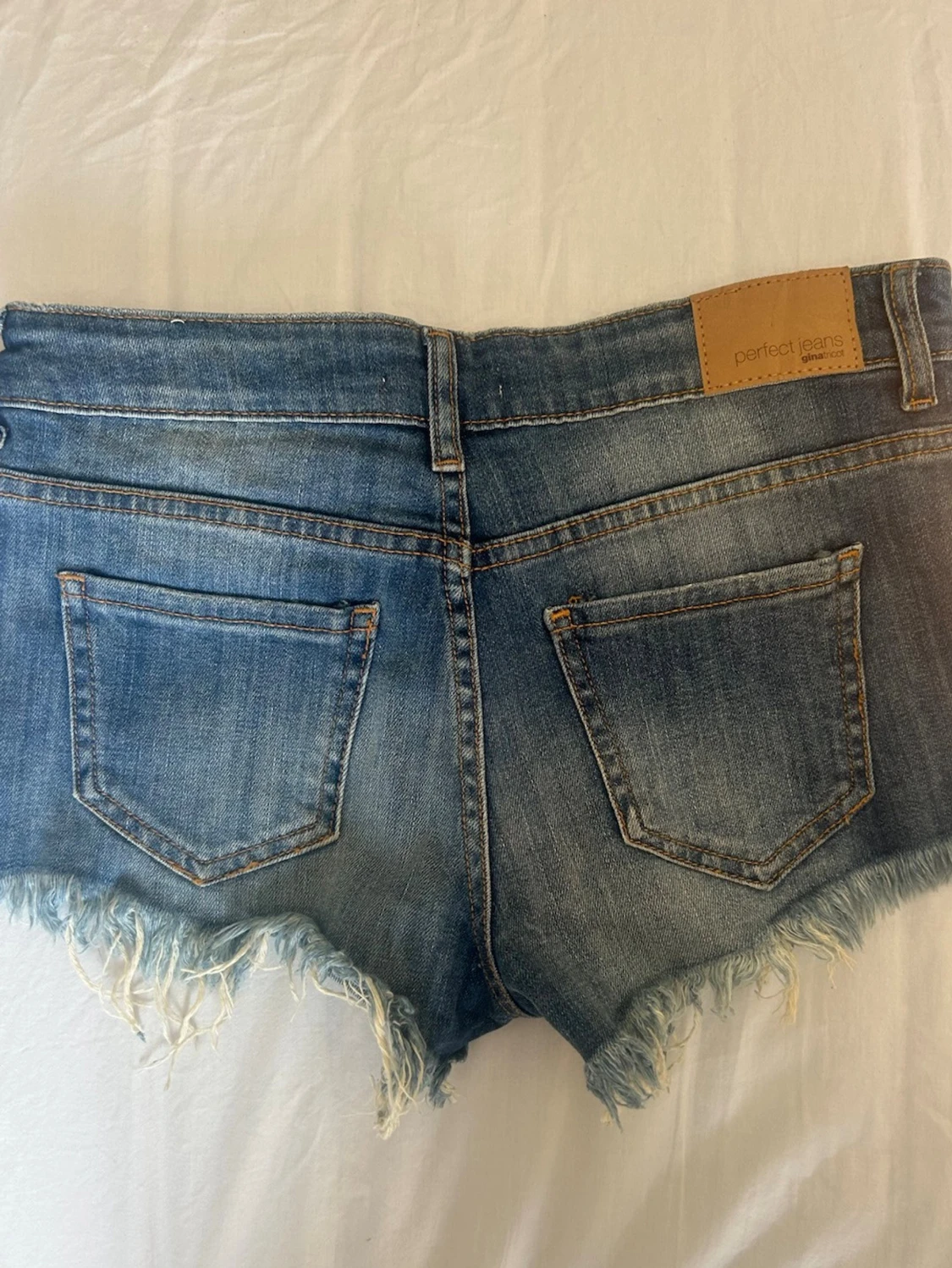 Lågmidjade blå jeansshorts med fransig kant - 1