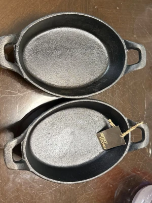 Ovala gjutjärnsformar med handtag - Två robusta ovala formar i svart gjutjärn från Senso Kitchen. Båda har praktiska handtag på sidorna för enkel hantering och en rå, matt finish. Perfekta för matlagning och servering direkt från ugnen till bordet.