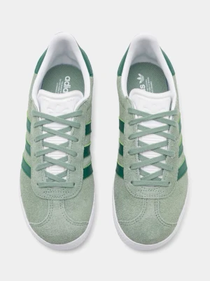 Adidas Gazelle gröna sneakers - Snygga Adidas Gazelle sneakers i ljusgrönt mocka med klassiska mörkgröna ränder på sidorna och vit sula. Skorna har vit plös och häl med Adidas-logga samt matchande gröna skosnören. Nypris 849kr