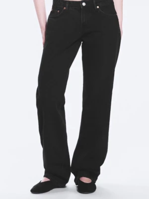Svarta raka/wide jeans med låg midja - Snygga svarta jeans med rak/wide passform och låg midja. Klassisk femficksmodell med knapp och dragkedja framtill. Jeansen har en tidlös look och är tillverkade i ett kraftigare denimtyg som ger en schysst känsla.