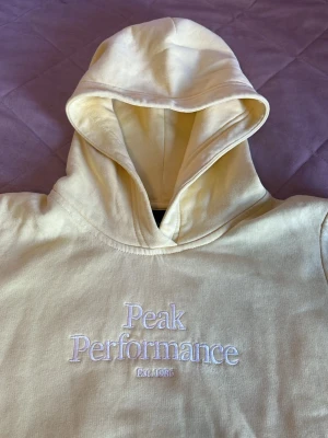 Ljus gul Hoodie - En Hoodie från Peak performance storlek 150 har inte använt den, säljer för att den är för liten. 