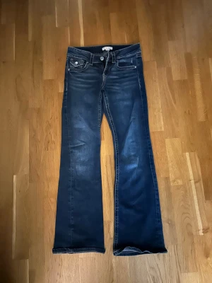 Mörkblåa low waist bootcut jeans med kontrastsömmar - Snygga mörkblåa low waist bootcut jeans med kontrastsömmar från Gina tricot i storlek 152. Jeansen är i nyskick och endast använt en gång💕😊