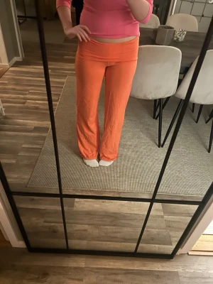 Coral yogapants i tall - Säljer ett par snygga coral yogapants med låg midja och utsvängda ben. Byxorna har en mjuk och stretchig känsla, perfekta för chill dagar hemma eller när du vill ha en färgklick i din outfit. 