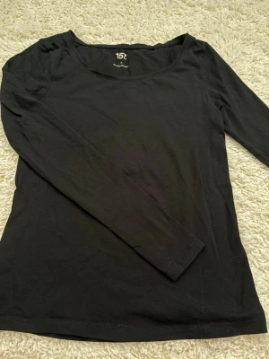 Svart långärmad topp från lager 157 - En enkel och stilren svart långärmad topp från lager 157. Tillverkad i mjuk bomull med lite elastan för extra stretch och bekväm passform. Perfekt basplagg med rund halsringning och normal passform.
